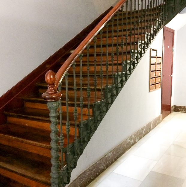 Escalera de madera antigua y buzones antes de rehabilitación del portal en Calle Corrida de Gijón.