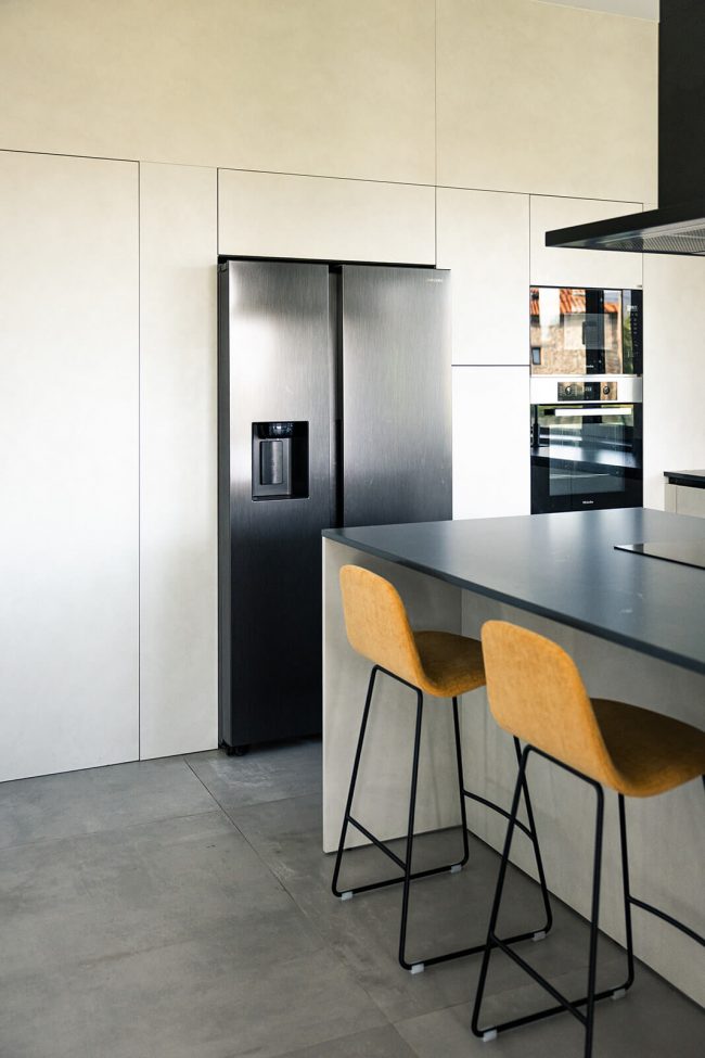 Cocina moderna con electrodomésticos ocultos. Dolmen Arquitectos