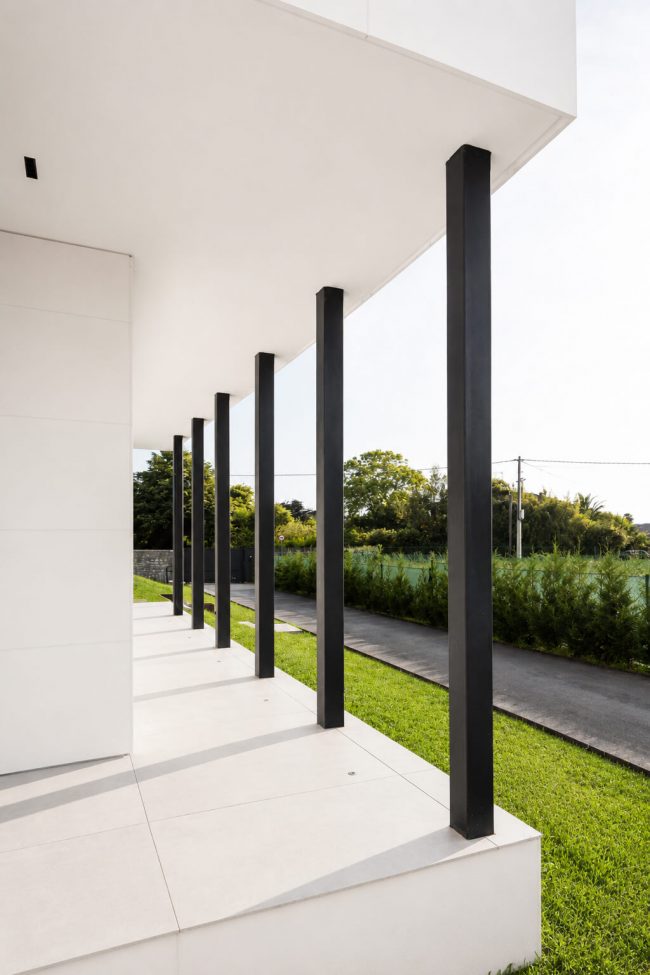 Columnas entrada cubierta moderna vivienda unifamiliar Asturias. Dolmen Arquitectos
