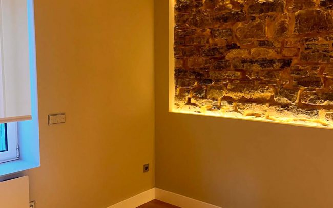 iluminación muro salón comedor de piso reformado en Gijón, proyecto de Dolmen Arquitectos