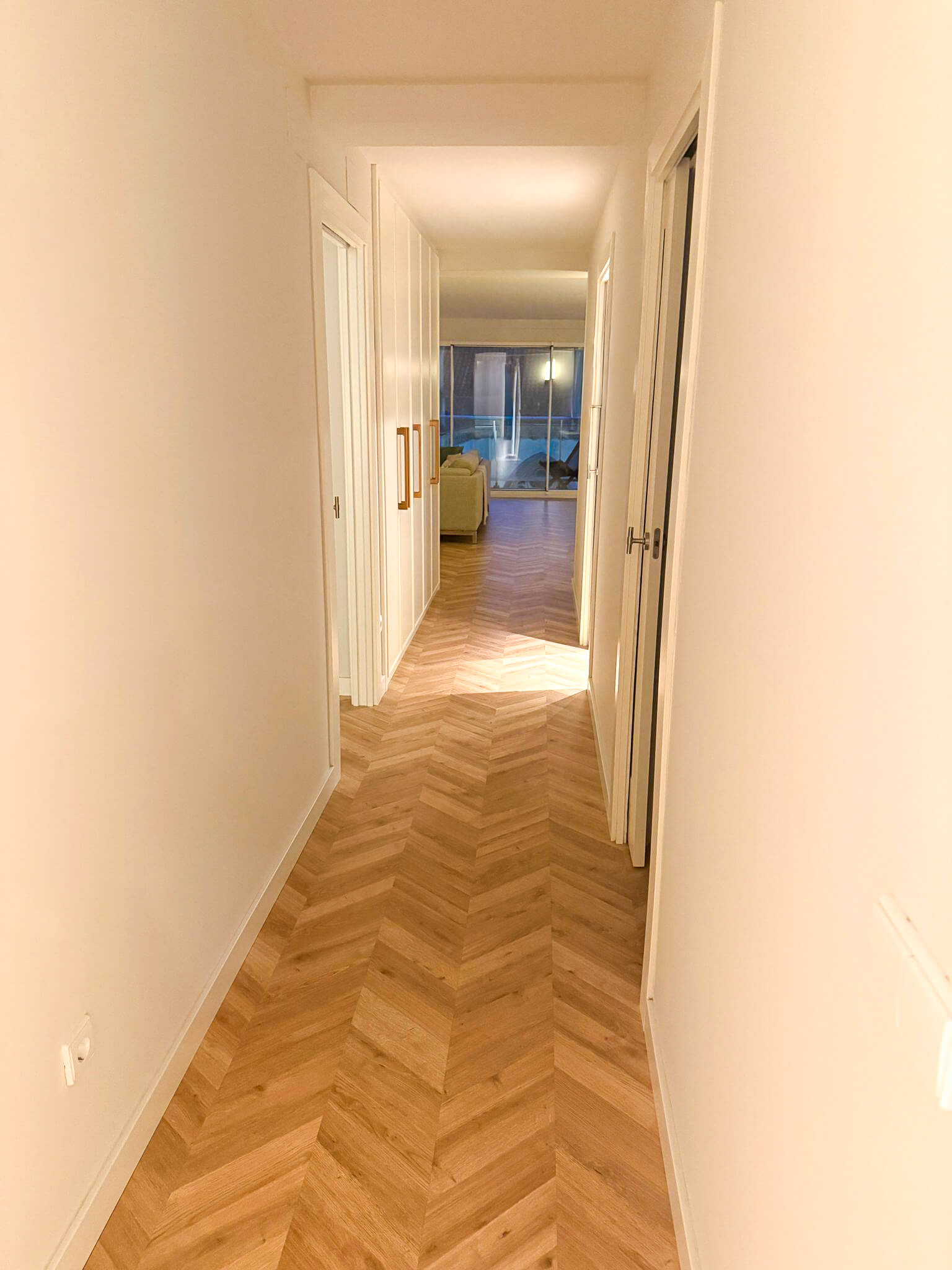 Pasillo con suelo de madera en Reforma interior de piso en el centro de Gijón, proyectada por Dolmen Arquitectos