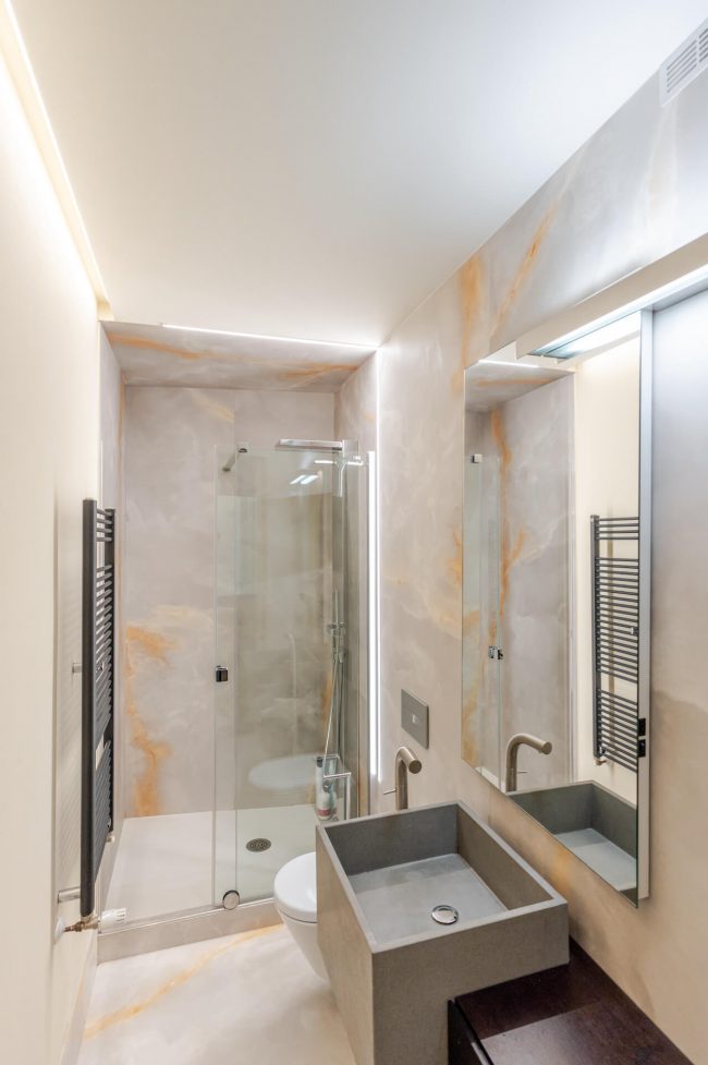 Baño principal reformado en piso de Oviedo con zona de lavabo y ducha acristalada