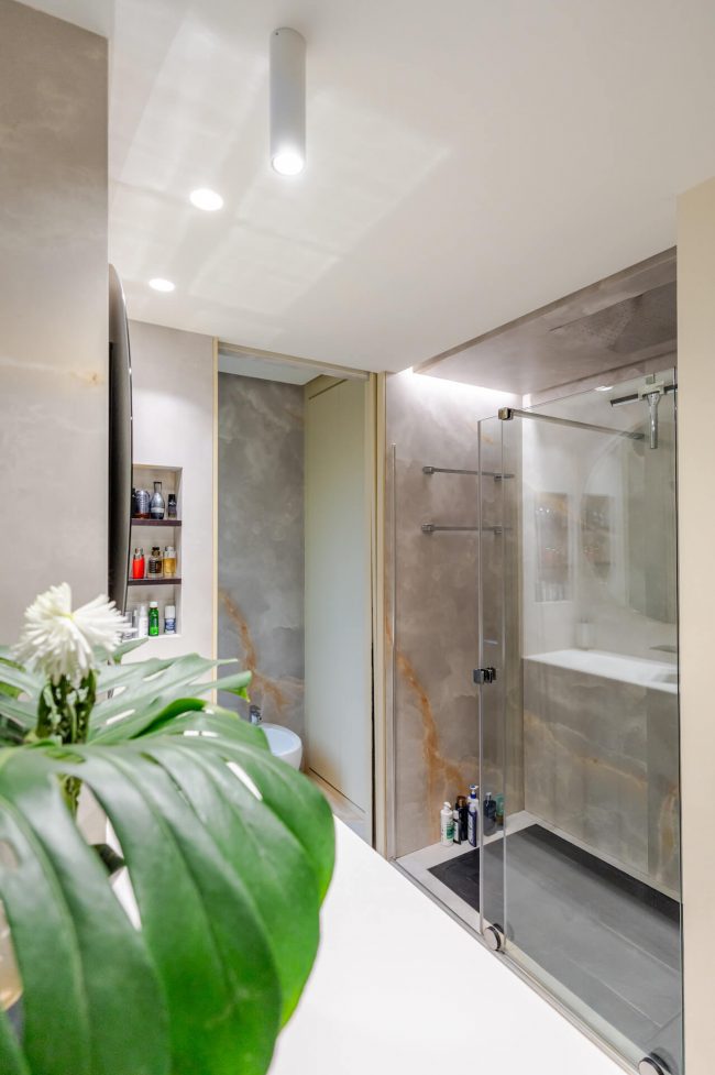 Baño principal reformado en piso de Oviedo con zona de lavabo y ducha acristalada