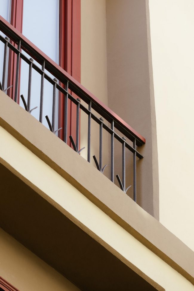 Detalle de rejería de hierro restaurada, en la fachada de edificio en la Calle Agua de Gijón.